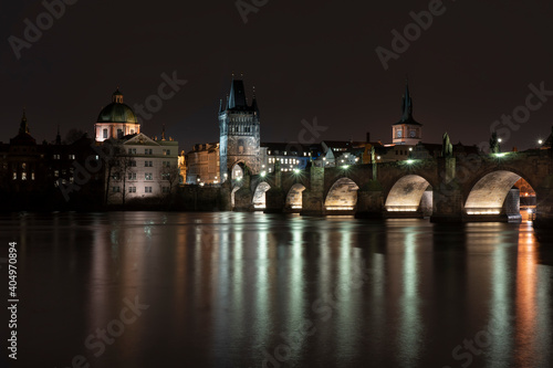 view of Charles Bridge on the river Vltava and light from street sovetleni at night in the center of Prague