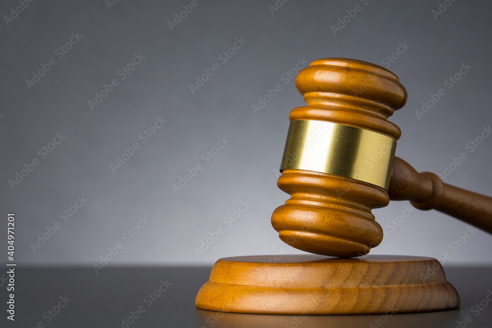Wooden judge gavel against grey background , close up Wooden judge gavel against grey background , close up