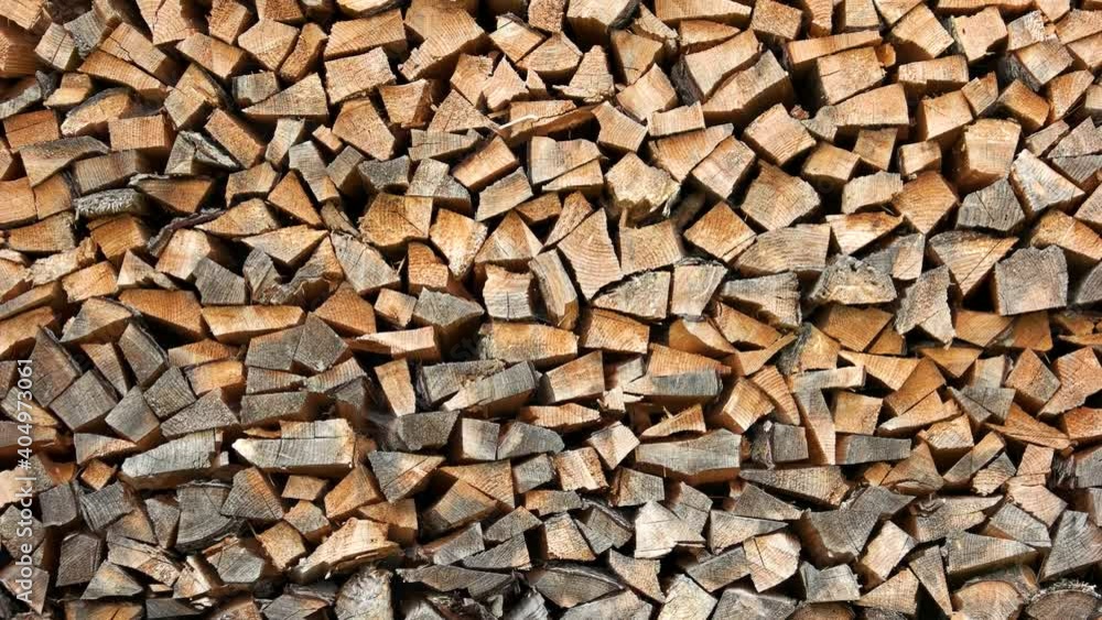 Stacked pile of chopped wood. Stacked dry firewood logs close up. Wood for winter heating in the village stove. Stacked pile of chopped wood. Stacked dry firewood logs close up. Wood for winter heating in the village stove.