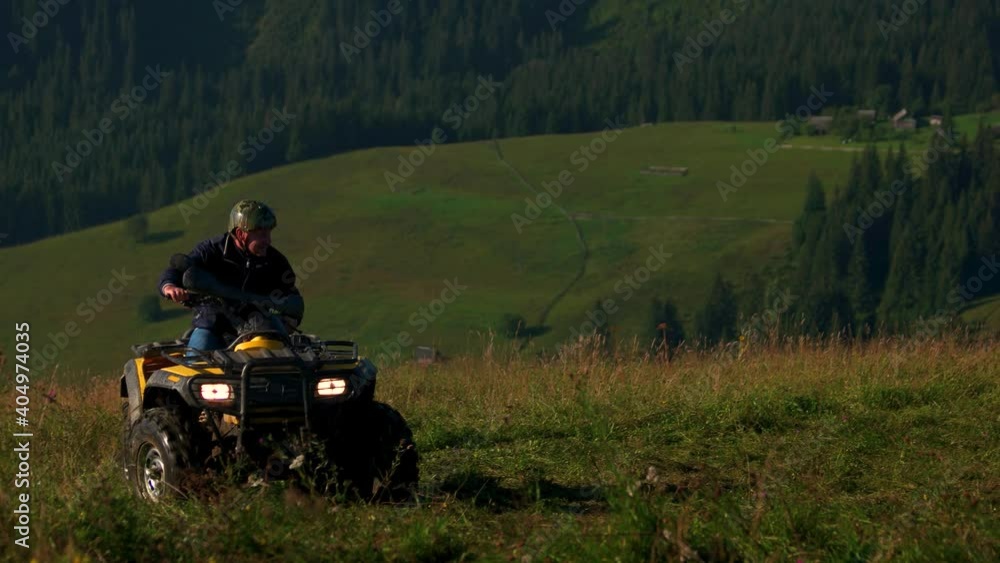 Mountain landscape with tourists on quad bikes. Three men riding quad bikes on grassy hills. ATV quad bike tour. Mountain landscape with tourists on quad bikes. Three men riding quad bikes on grassy hills. ATV quad bike tour.