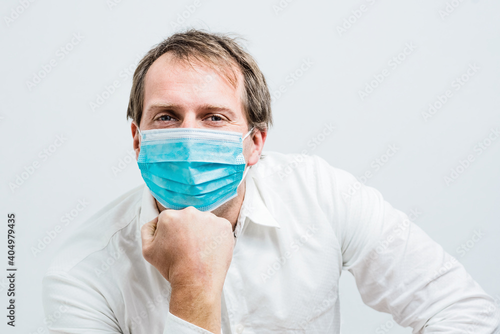 Closeup of young man looking in to the camera with mask holding it on hands.