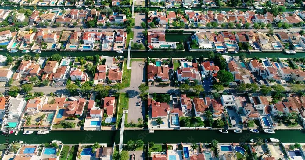 Houses of a Surbubian community. Flying over red roofs in idyllic suburban town with garden and waterway between houses 4K Houses of a Surbubian community. Flying over red roofs in idyllic suburban town with garden and waterway between houses 4K