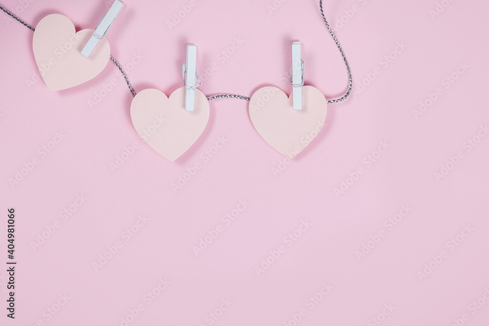 Hearts from paper scattered on pink background