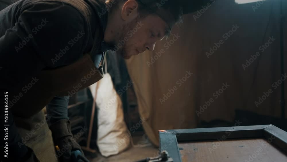 Worker wearing a mask and gloves soldering metal parts Worker wearing a mask and gloves soldering metal parts
