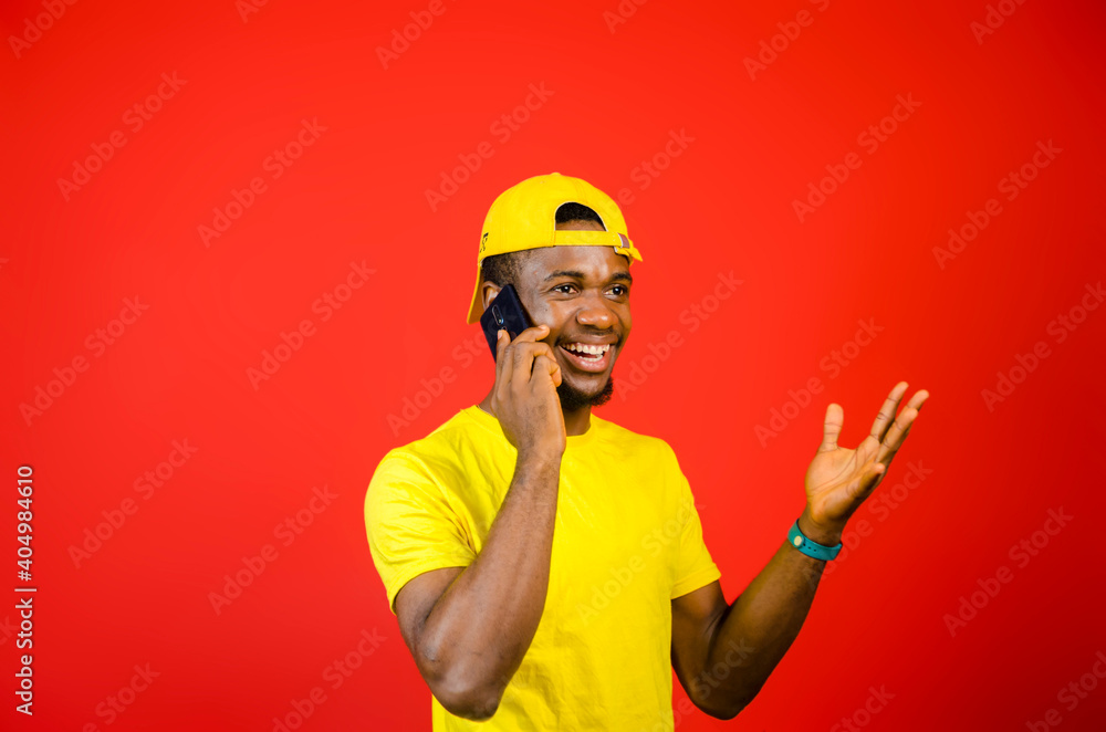 handsome nigerian boy making call with his cell phone handsome nigerian boy making call with his cell phone