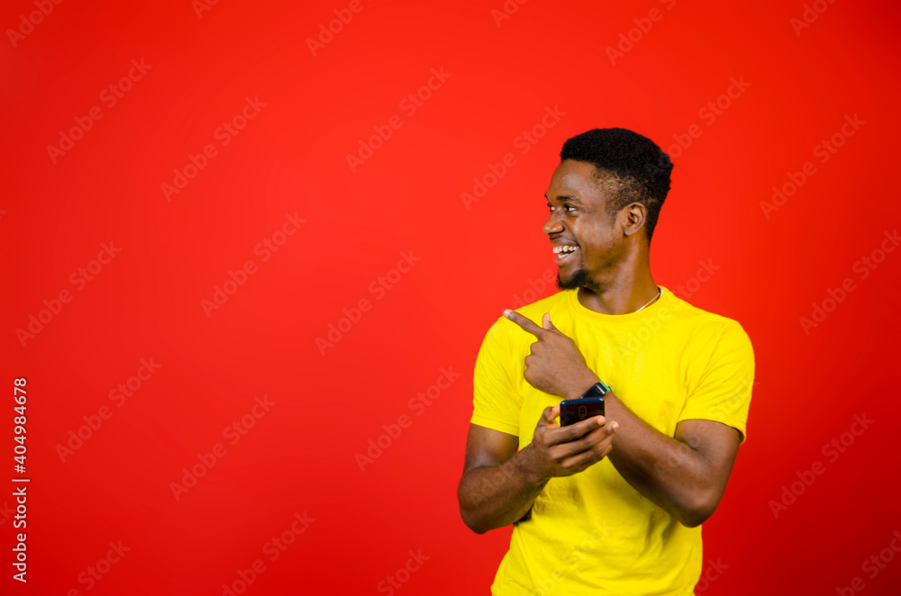 a young african boy feeling excited as he operate his cellphone a young african boy feeling excited as he operate his cellphone