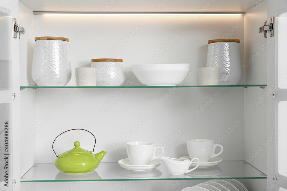 Obraz premium Open kitchen cabinet with different clean dishware