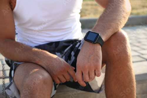 Man with fitness tracker after training outdoors, closeup