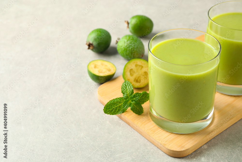 Fototapeta premium Fresh feijoa smoothie and fresh mint on grey table, closeup. Space for text