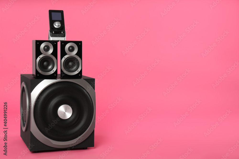 Modern powerful audio speaker system with remote on pink background, space for text Modern powerful audio speaker system with remote on pink background, space for text