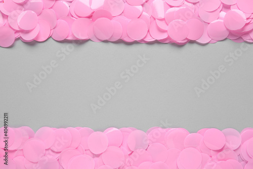 Pink confetti on light grey background, flat lay. Space for text © New Africa