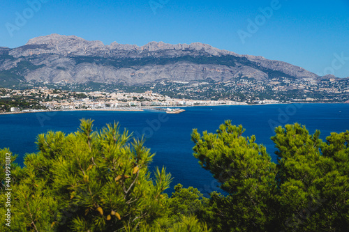 Coastal view to Atea over mediteranean sea and blurred pines in natural park 'Serra Gelada' in Albir, Spain