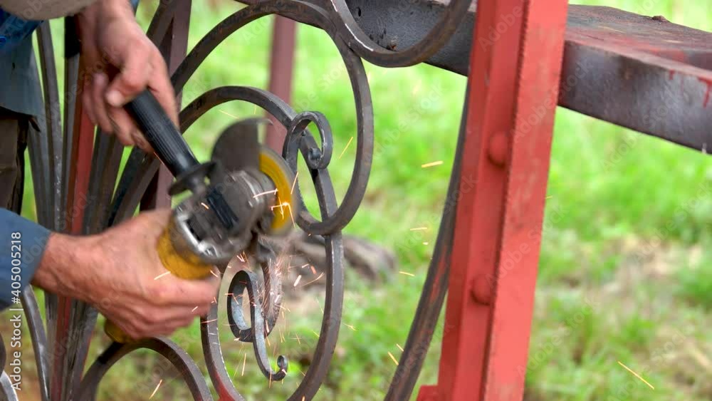 Engineer welds a gate. Worker welding with sparks. Engineer welds a gate. Worker welding with sparks.