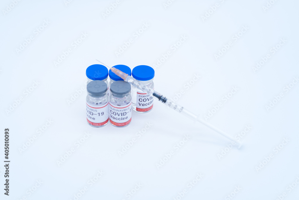 A medical syringe and five bottles of COVID-19 vaccine A medical syringe and five bottles of COVID-19 vaccine