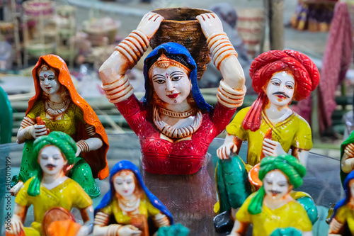 Colorful female Terracotta doll dressed in traditional Indian dress, carrying big basket in her back , made in Krishnanagar, Nadia, West Bengal, on display for sale during Handicraft Fair in Kolkata.