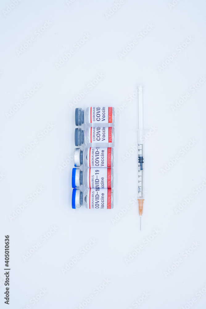 A medical syringe and five bottles of COVID-19 vaccine A medical syringe and five bottles of COVID-19 vaccine