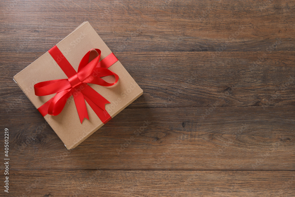 Brown and red gift boxes and red ribbon on wooden background with space Brown and red gift boxes and red ribbon on wooden background with space