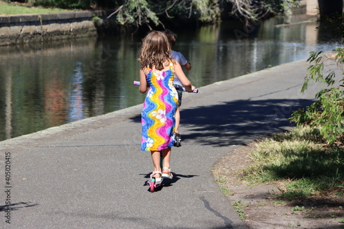 Young girl riding her scooter near a canal, Elwood, Melbourne, Victoria, Australia.
