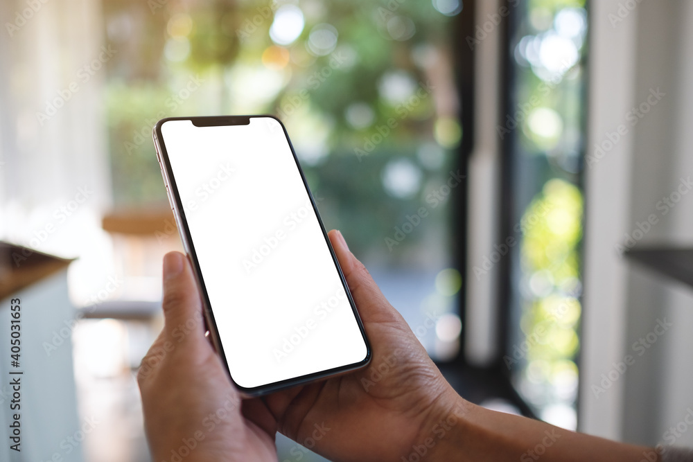 Mockup image of a woman holding mobile phone with blank white desktop screen Mockup image of a woman holding mobile phone with blank white desktop screen