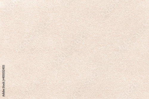 Photos Light beige matte background of suede fabric, closeup