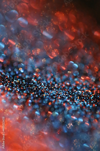 Wallpaper phone shining glitter.Glitter radiance surface. Red and blue glitter with shining bokeh on a black background.Festive bright background. New Year and Christmas background. 