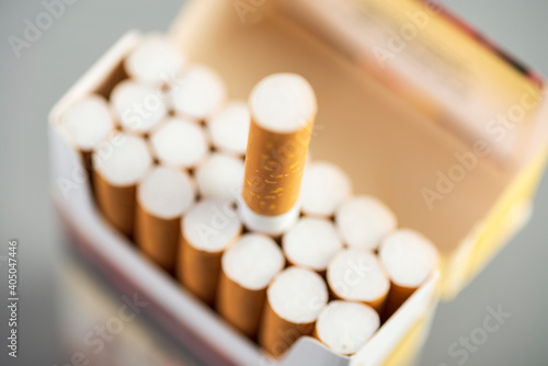 Open pack of cigarettes with one stretched out cigarette close-up