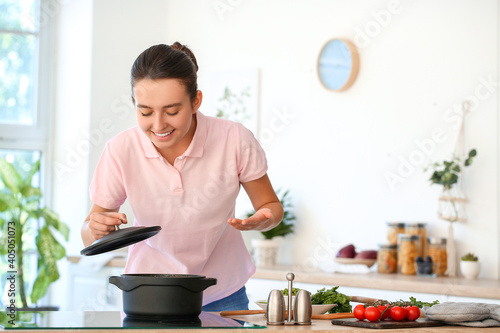 Woman cooking tasty soup in...