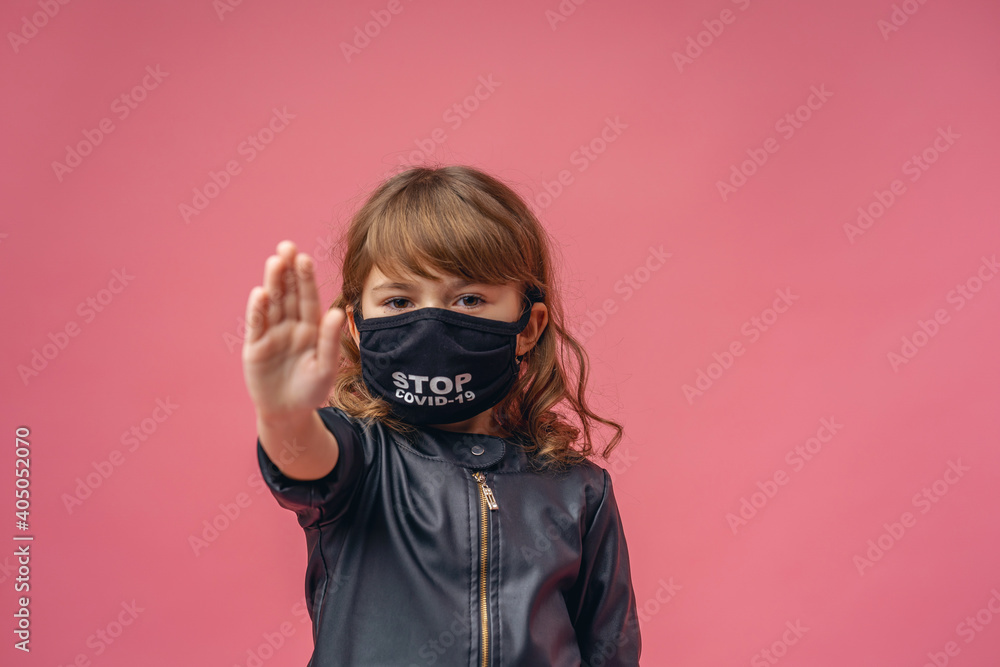 little girl in medical mask makes a stop gesture during the coronavirus pandemic little girl in medical mask makes a stop gesture during the coronavirus pandemic