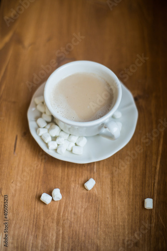 A cup of marshmallow coffee on a brown wooden table