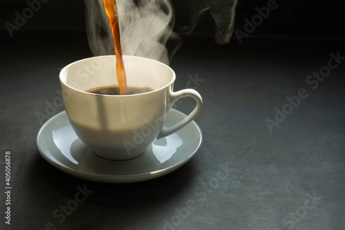 The steam from Pouring coffee into cup , A cup of fresh coffee on rusty metal wall with copy space. A scattering of coffee beans with a cup of coffee. Coarse fabric ,hot food and healthy meal concept