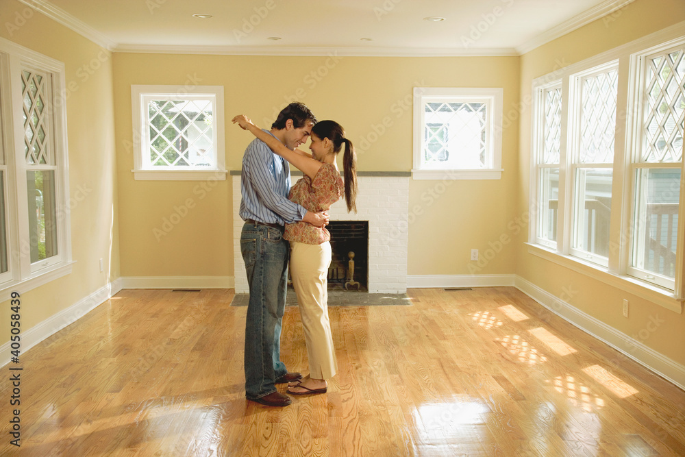Hispanic couple hugging in new house Hispanic couple hugging in new house