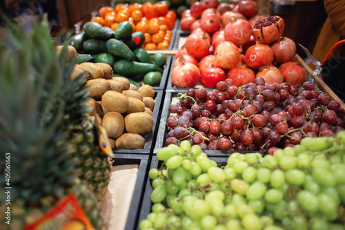 Various fruits and berries are sold at the tropical fruit shop. Counter with grapes  pineapples and pomegranates