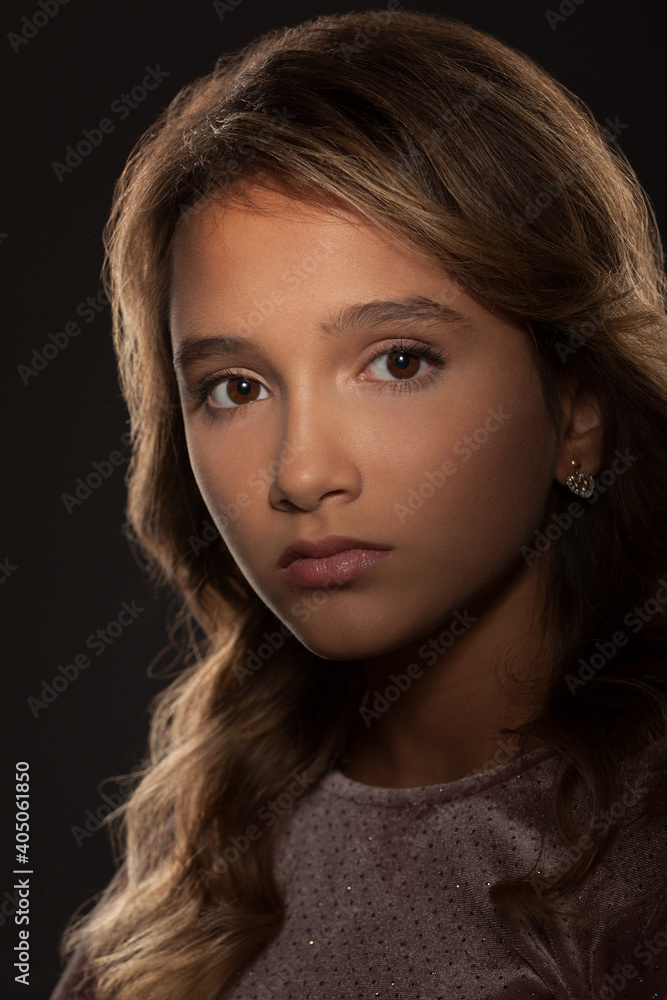 portrait of a beautiful teenage girl with a beautiful hairstyle and Hollywood lighting on a gray background portrait of a beautiful teenage girl with a beautiful hairstyle and Hollywood lighting on a gray background