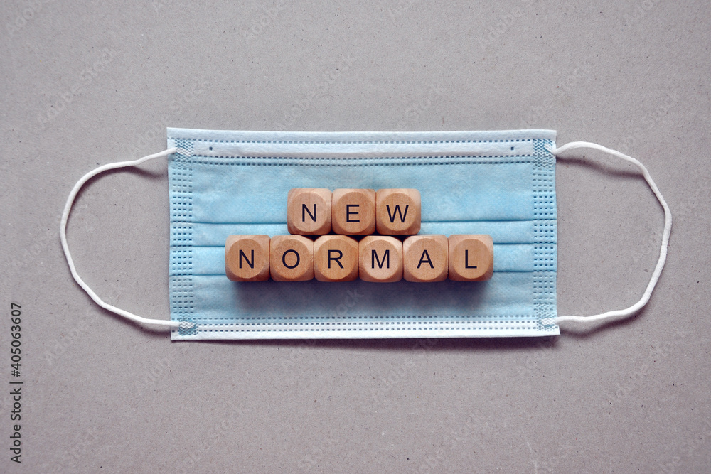 Wooden cubes with the inscription new normal in a medical mask. a symbol of the new normal and the global pandemic. Waiting for the end of the pandemic Wooden cubes with the inscription new normal in a medical mask. a symbol of the new normal and the global pandemic. Waiting for the end of the pandemic