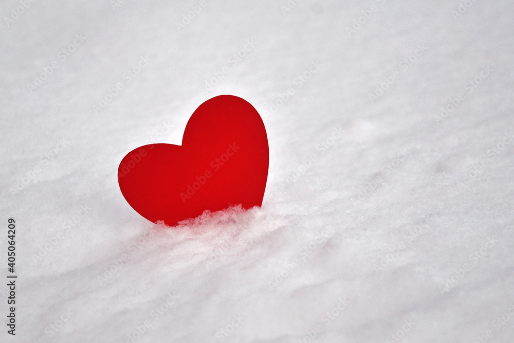 One red heart in the snow. A symbol of undivided love. Valentine's Day