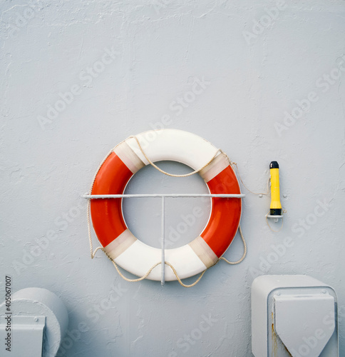 Close up of red and white life preserver ring hanging on side of ship