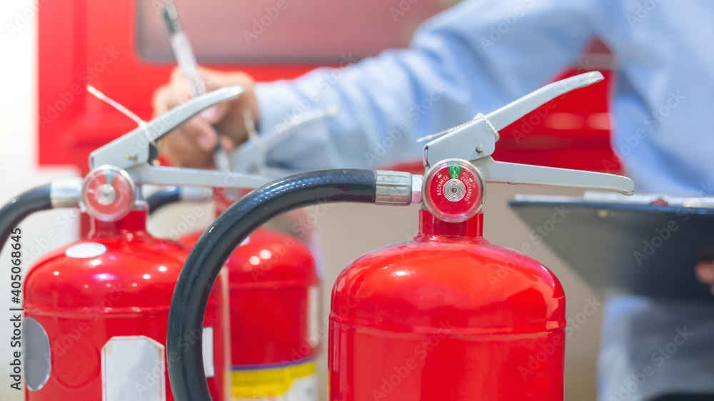 Expert engineers inspect fire extinguishers to be ready for use. Expert engineers inspect fire extinguishers to be ready for use.