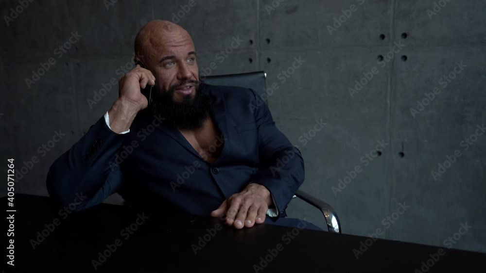 businessman is communicating by mobile phone in office, portrait of brawny man businessman is communicating by mobile phone in office, portrait of brawny man