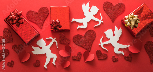 Flying cupid silhouette with hearts, gifts, happy Valentine's Day banners, paper art style. Amour on red paper