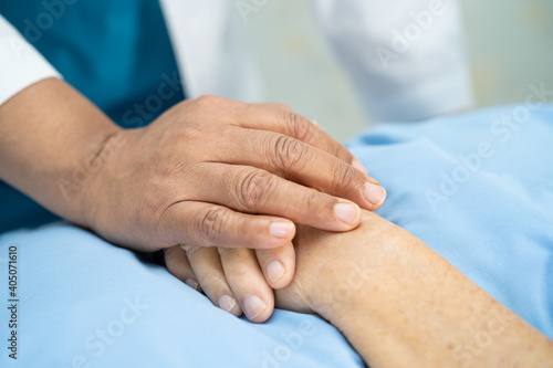 Doctor touching hand Asian senior or elderly old lady woman patient with love, care, helping, encourage and empathy at nursing hospital ward, healthy strong medical concept