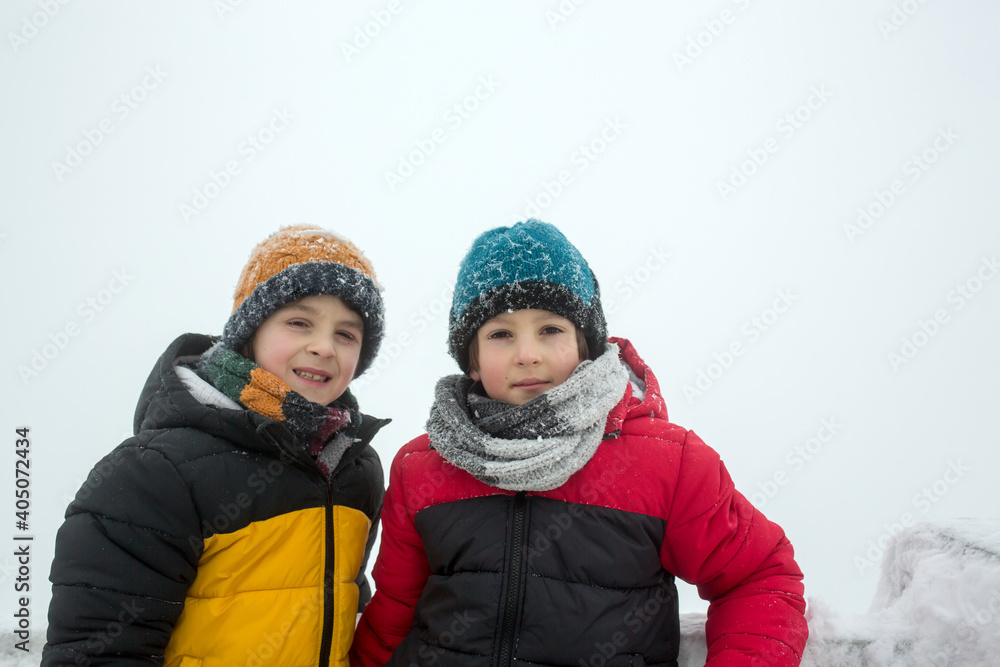Sweet happy children, brothers, playing in deep snow in forest Sweet happy children, brothers, playing in deep snow in forest