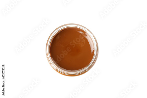 Glass jar with caramel condensed milk isolated on white background