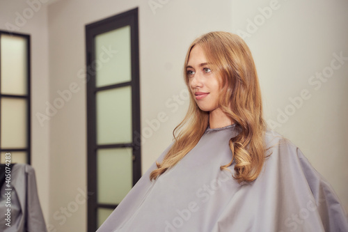 Long hair woman. Hairdresser treatment. Repair procedure. Sit at salon. Bride hairstyle. Curly styling. Adult female person. Prom lady preparation. Blonde dry. Copyspace