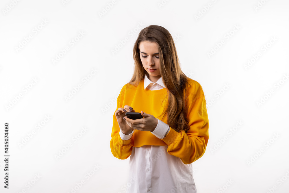 Smiling young brunette womanis using mobile phone, typing sms message. Technology, youth and communication concept Smiling young brunette womanis using mobile phone, typing sms message. Technology, youth and communication concept