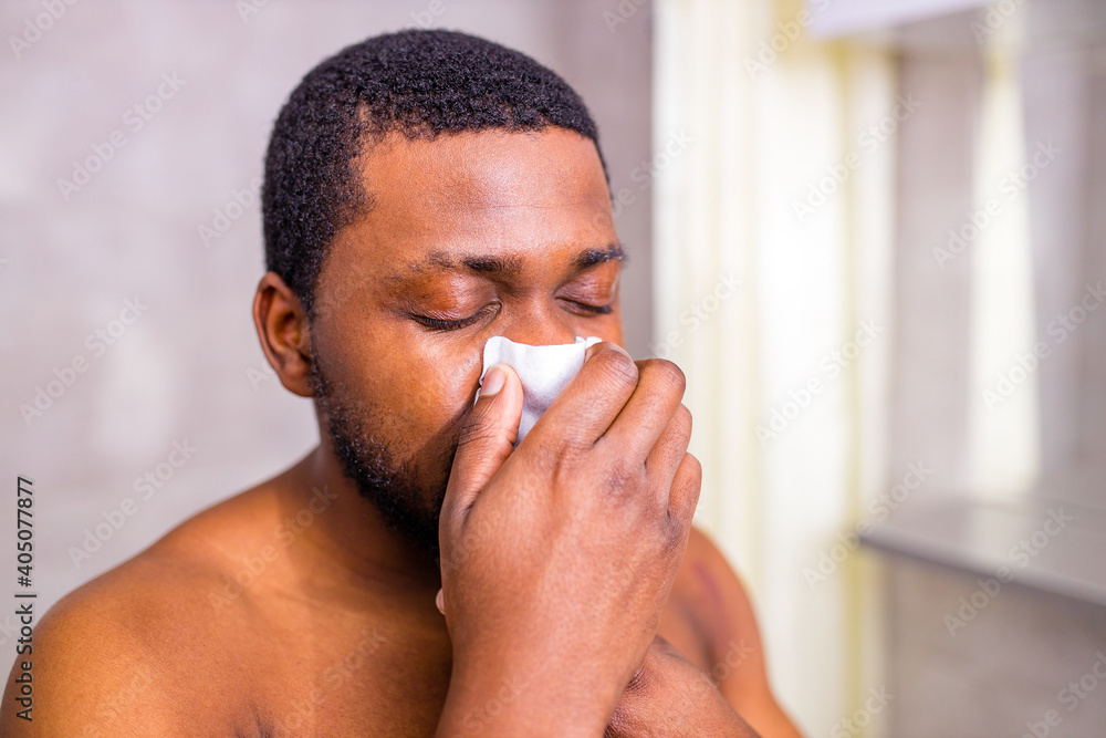 Fototapeta premium african american man snot symptom feeling bad stay at home looking at mirrror in bathroom