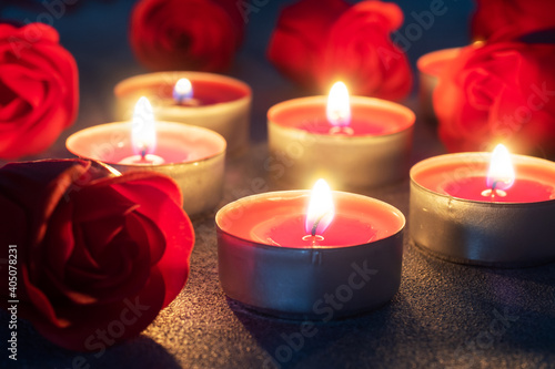 Red roses and burning candles  close up  romantic greeting card. concept of Valentine s Day.