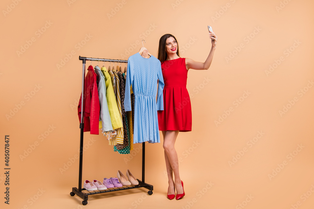 Full size photo of pretty lady make selfie showroom client choose dress wear glamour outfit red stilettos isolated on beige color background Full size photo of pretty lady make selfie showroom client choose dress wear glamour outfit red stilettos isolated on beige color background