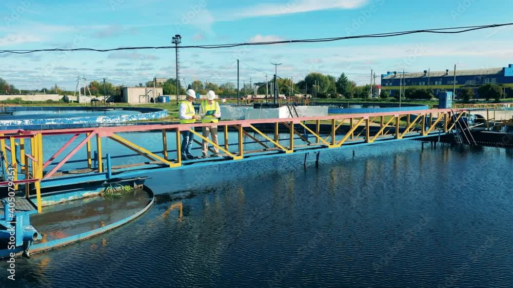 Sewage cleaning plant with two engineers having a talk Sewage cleaning plant with two engineers having a talk