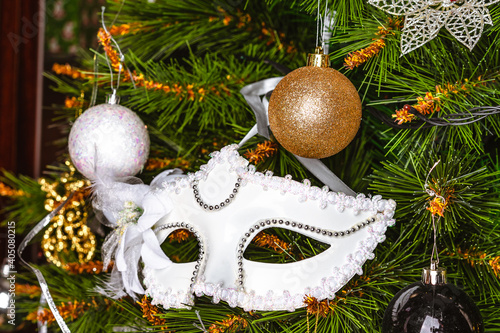 Carnival mask and toys on a decorated Christmas tree