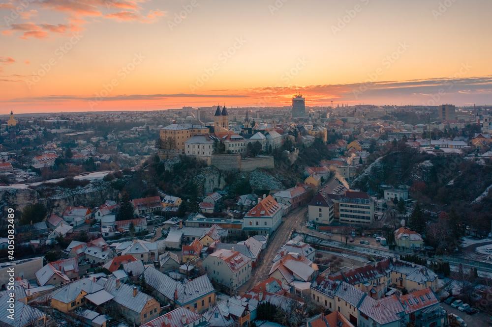 Veszprém, Hungary - Amazing aerial view of Veszprém downtown and castle district on a winter morning with stunning golden sunrise. Historical old buildings, church and much more.